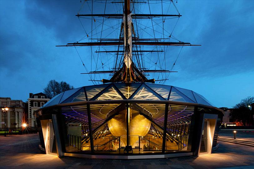 Cutty Sark shown at night with the visitor centre directly in front of it